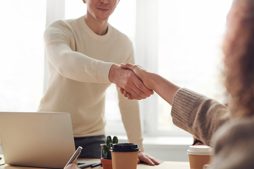 An employee shaking hands in a meeting.